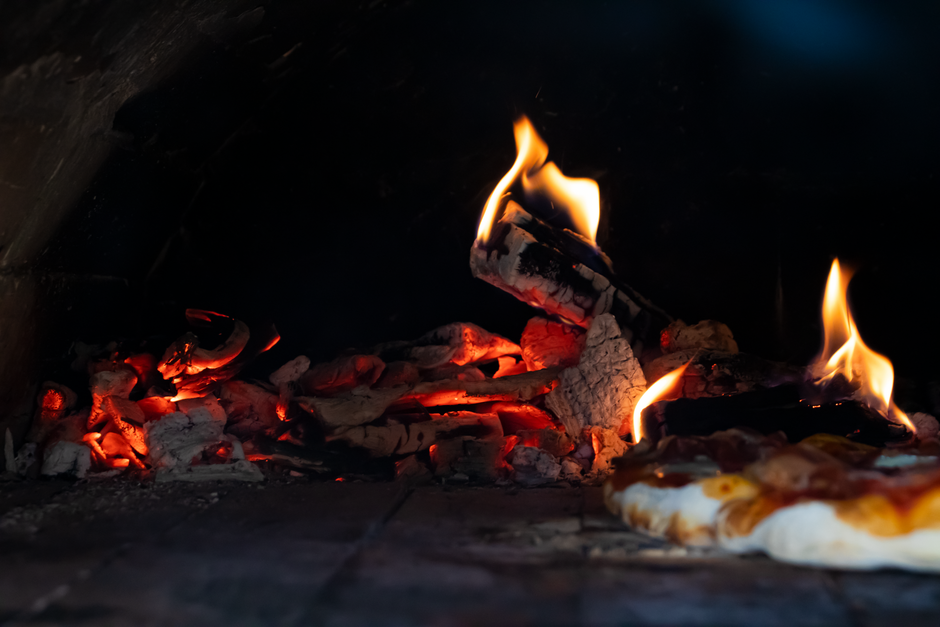 Four à pizza traditionnel au feu de bois, braises et flammes