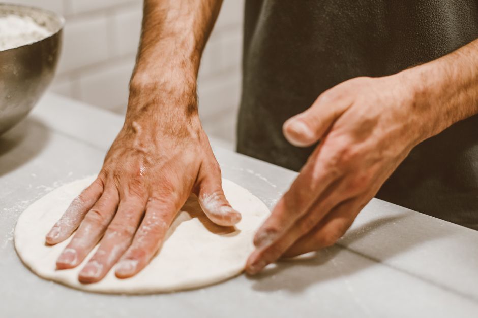 Mains façonnant une pâte à pizza